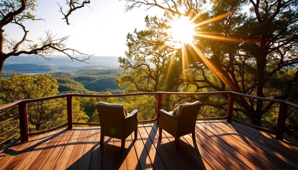 A tranquil private deck overlooking the lush, rolling hills of the Texas Hill Country. Warm sunlight filters through the gently swaying trees, casting a soft, golden glow over the weathered wooden planks. A pair of cozy armchairs invite visitors to sink in and take in the serene panorama, with distant blue hills forming the backdrop. The overall atmosphere evokes a sense of peaceful seclusion, perfect for a spiritual retreat amidst the natural beauty of the region.